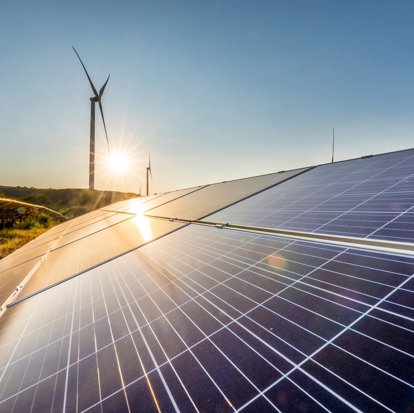 Photo image of a wind turbine and solar energy panels representing renewable energy sources