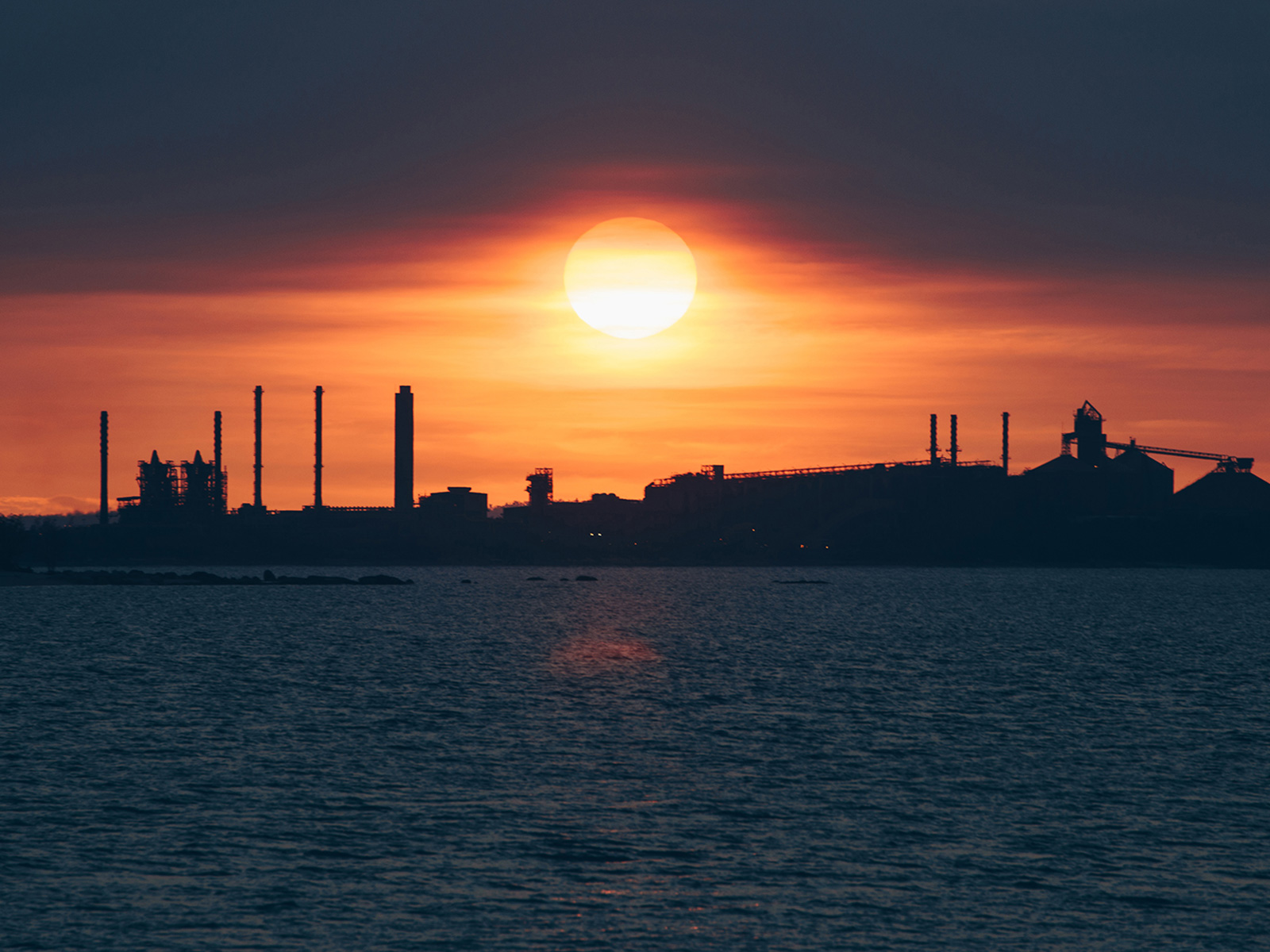 Sun setting over a power station