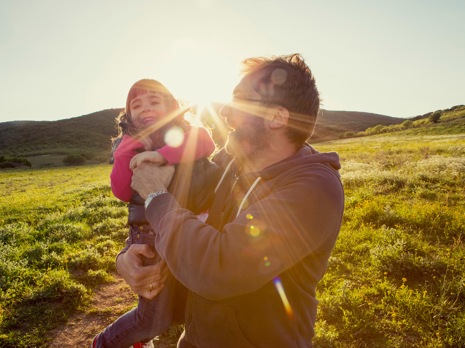 Father and child laughing in the summer sun
