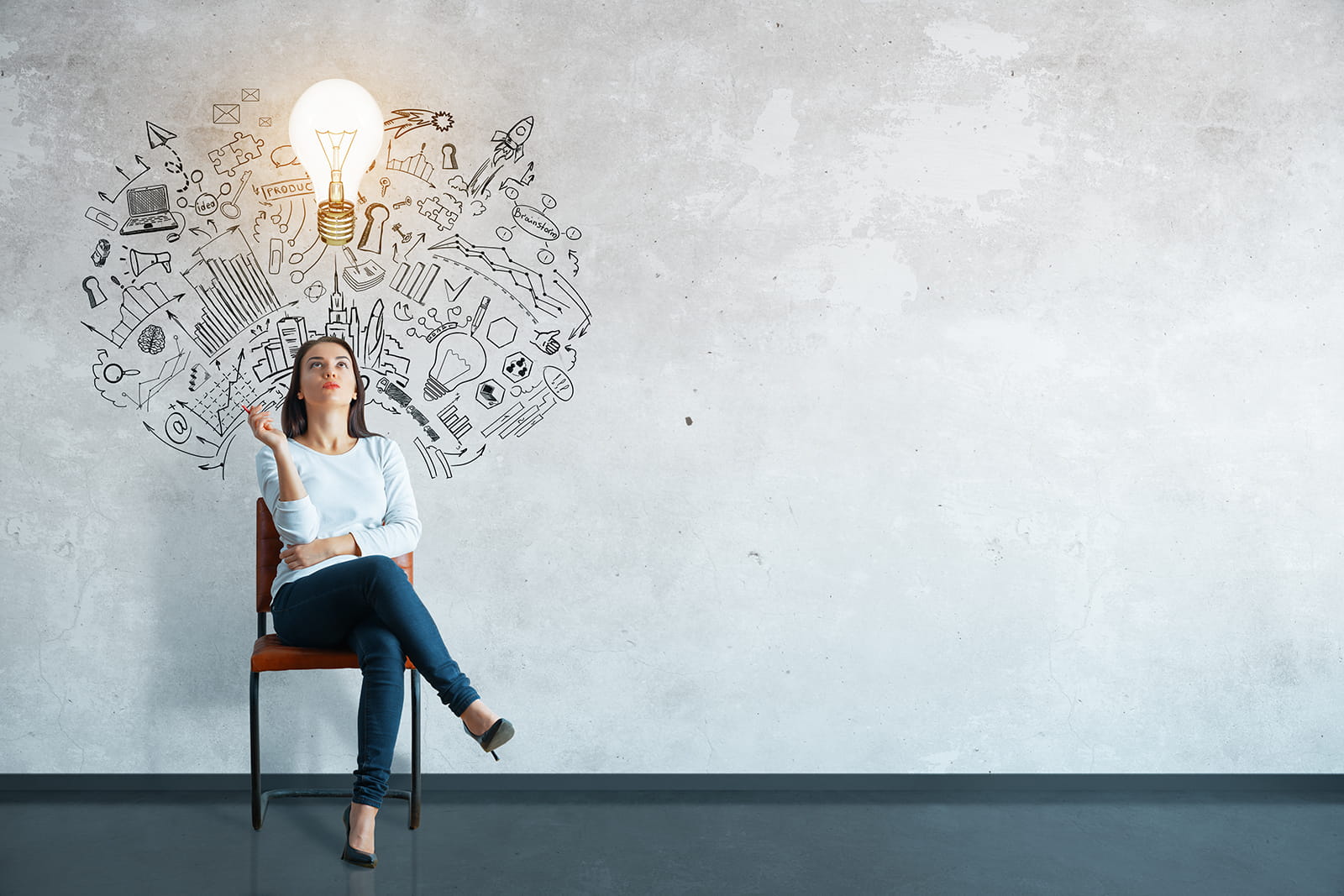 Woman sitting in chair against a grey backdrop, a light bulb and ideas above her head