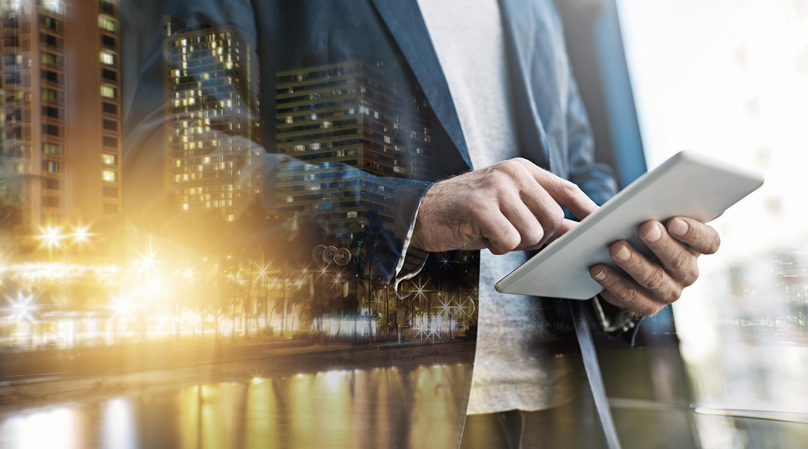 Man reading digital tablet, cityscape in foreground